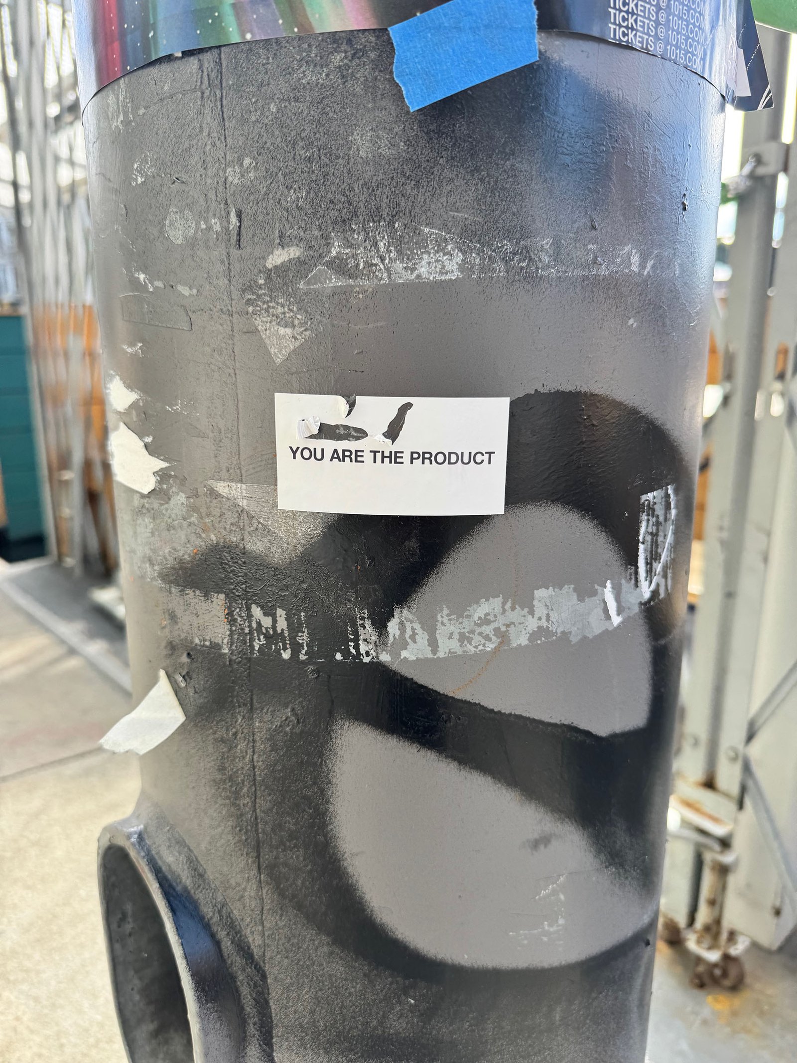 Control Text field test sticker reading “You Are The Product” placed on a painted street pole in San Francisco.