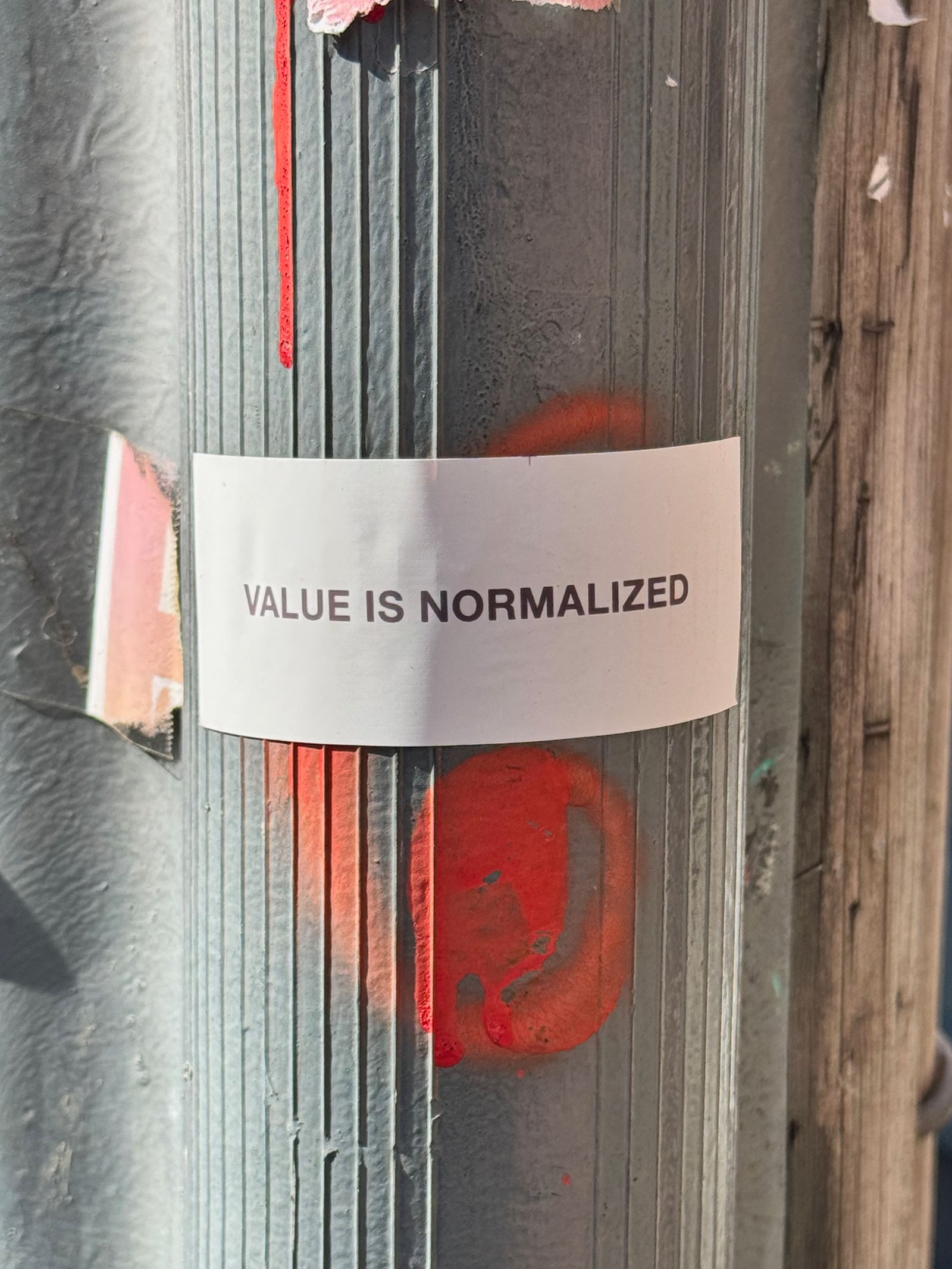 Control Text field test sticker reading “Value Is Normalized” placed on a street pole in San Francisco.